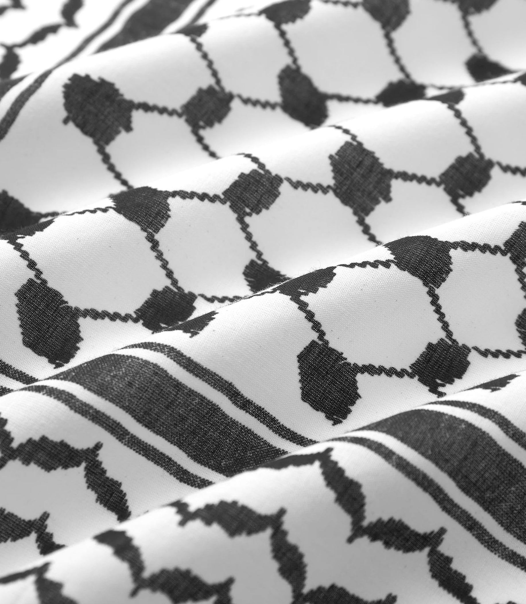 A black and white patterned design on white fabric, featuring traditional geometric shapes and lines.